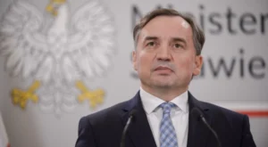 Zbigniew Ziobro rzekomo miał doznać zawału po powrocie do Polski. Nowe doniesienia w sprawie Sądu Najwyższego i wyników wyborów

Wokół Zbigniewa Ziobry ponownie pojawiły się informacje, które wywołały duże zainteresowanie opinii publicznej. W przestrzeni medialnej zaczęły krążyć doniesienia sugerujące, że były minister sprawiedliwości miał rzekomo doznać zawału po powrocie do Polski. Jednocześnie pojawiają się twierdzenia dotyczące nowych działań Sądu Najwyższego związanych z wynikami wyborów prezydenckich. Na tym etapie należy jednak podkreślić, że część tych informacji nie została oficjalnie potwierdzona.

Sprawa jest szczególnie emocjonująca ze względu na wcześniejsze kontrowersje wokół Zbigniewa Ziobry i jego sytuacji prawnej. Były minister od dłuższego czasu znajduje się w centrum zainteresowania opinii publicznej, a jego nazwisko regularnie pojawia się w kontekście sporów politycznych i postępowań dotyczących funkcjonowania wymiaru sprawiedliwości.

Niepotwierdzone informacje o stanie zdrowia

Najbardziej niepokojącym elementem najnowszych doniesień są informacje dotyczące zdrowia Ziobry. Według krążących przekazów polityk miał rzekomo doznać zawału po powrocie do Polski. Nie ma jednak podstaw, aby przedstawiać tę informację jako potwierdzony fakt bez oficjalnego komunikatu lekarzy, rodziny lub przedstawicieli samego polityka.

Informacje dotyczące zdrowia osób publicznych wymagają szczególnej ostrożności. W przypadku tak poważnego wydarzenia jak zawał serca bardzo łatwo może dojść do rozpowszechnienia plotki, która następnie jest powielana przez kolejne profile i portale bez niezależnego potwierdzenia.

Dlatego obecnie najważniejsze pozostaje ustalenie, czy pojawił się wiarygodny komunikat potwierdzający stan zdrowia byłego ministra. Do tego czasu należy mówić o niepotwierdzonych doniesieniach, a nie o pewnym zdarzeniu.

Powrót do Polski i polityczne emocje

Sytuacja Ziobry od dawna budzi ogromne emocje. Były minister jest jednym z najbardziej rozpoznawalnych polityków polskiej prawicy i przez lata odgrywał ważną rolę w sporach dotyczących reformy sądownictwa.

Jego działalność polityczna była wielokrotnie krytykowana przez przeciwników, podczas gdy jego zwolennicy przedstawiali go jako polityka zdecydowanie broniącego własnych przekonań dotyczących państwa i wymiaru sprawiedliwości.

Każda informacja dotycząca jego sytuacji prawnej lub osobistej szybko staje się więc przedmiotem politycznej dyskusji. Tak jest również w przypadku najnowszych doniesień.

Wątek Sądu Najwyższego

Drugim elementem sprawy są informacje dotyczące Sądu Najwyższego i wyników wyborów prezydenckich. W internecie pojawiły się twierdzenia, że Sąd Najwyższy miał zażądać przedstawienia „prawdziwych wyników wyborów” w ciągu 48 godzin.

Takie sformułowanie wymaga jednak dokładnego wyjaśnienia. Oficjalne wyniki wyborów w Polsce są ustalane i ogłaszane przez Państwową Komisję Wyborczą na podstawie procedur przewidzianych prawem. Sąd Najwyższy pełni natomiast określone funkcje związane z kontrolą wyborów, w tym rozpatrywaniem protestów wyborczych oraz stwierdzeniem ważności wyboru prezydenta.

Dlatego samo pojawienie się informacji o żądaniu określonych dokumentów czy danych nie oznacza automatycznie, że oficjalne wyniki wyborów zostały zakwestionowane albo że istnieją inne „prawdziwe” wyniki.

Kim jest Marciniak w tej sprawie?

W krążących przekazach pojawia się również nazwisko Marciniaka. Warto jednak zachować ostrożność w opisywaniu jego rzekomej reakcji. Określenie, że dana osoba jest „w panice”, jest oceną lub elementem narracji medialnej, a nie obiektywnym faktem, chyba że istnieje konkretna wypowiedź lub dokument potwierdzający takie zachowanie.

W przypadku osób pełniących funkcje publiczne szczególnie istotne jest oddzielenie informacji od komentarza. Można opisać oficjalne decyzje, dokumenty czy wypowiedzi, ale przypisywanie komuś strachu, paniki lub innych emocji wymaga wiarygodnego źródła.

48 godzin może budzić pytania

Jeżeli rzeczywiście pojawiło się formalne żądanie przedstawienia określonych dokumentów w terminie 48 godzin, istotne byłoby ustalenie dokładnej treści takiego postanowienia lub pisma. Sam termin może mieć znaczenie proceduralne, ale bez znajomości dokumentu nie można jednoznacznie określić jego konsekwencji.

Właśnie dlatego w tego typu sprawach kluczowe znaczenie mają dokumenty źródłowe. Nagłówki publikowane w mediach społecznościowych mogą być znacznie bardziej sensacyjne niż treść decyzji organu państwowego.

Spór o wybory może mieć poważne konsekwencje

Każde podważenie prawidłowości procesu wyborczego jest sprawą o ogromnym znaczeniu dla państwa. Wybory prezydenckie są jednym z najważniejszych mechanizmów demokratycznych, dlatego wszelkie zarzuty dotyczące ich przebiegu powinny być analizowane przede wszystkim na podstawie dowodów i oficjalnych dokumentów.

Nie oznacza to jednak, że każda informacja o kontroli wyborów czy rozpatrywaniu protestów jest dowodem na istnienie nieprawidłowości. Kontrola prawidłowości wyborów jest częścią systemu demokratycznego i sama w sobie nie przesądza o wyniku postępowania.

Ziobro ponownie w centrum uwagi

Niezależnie od tego, jak zakończy się obecny spór, nazwisko Zbigniewa Ziobry ponownie znalazło się w centrum zainteresowania. Doniesienia dotyczące jego zdrowia połączone z informacjami o działaniach instytucji państwowych tworzą niezwykle emocjonalną narrację.

Najważniejsze pozostaje jednak rozdzielenie potwierdzonych informacji od niezweryfikowanych przekazów. Jeśli rzeczywiście doszło do poważnego zdarzenia zdrowotnego, powinny pojawić się wiarygodne informacje dotyczące stanu polityka. Jeśli natomiast Sąd Najwyższy podjął formalne działania dotyczące dokumentacji wyborczej, ich zakres powinien być możliwy do zweryfikowania w oficjalnych materiałach.

W obecnej sytuacji określenia takie jak „rzekomy zawał”, „panika” czy „prawdziwe wyniki wyborów” powinny być traktowane z dużą ostrożnością. Ostateczne ustalenia mogą bowiem znacząco różnić się od wersji przedstawianych w mediach społecznościowych.

Sprawa pokazuje również, jak szybko informacje dotyczące polskiej polityki mogą przerodzić się w ogromny medialny konflikt. W przypadku tak poważnych tematów, jak zdrowie polityka czy prawidłowość wyborów, najważniejsze powinny być fakty, oficjalne dokumenty oraz wypowiedzi osób bezpośrednio zaangażowanych w sprawę.

Dopiero wtedy będzie można odpowiedzialnie ocenić, co rzeczywiście wydarzyło się wokół Zbigniewa Ziobry i czy informacje dotyczące Sądu Najwyższego mają potwierdzenie w oficjalnych działaniach instytucji państwowych.